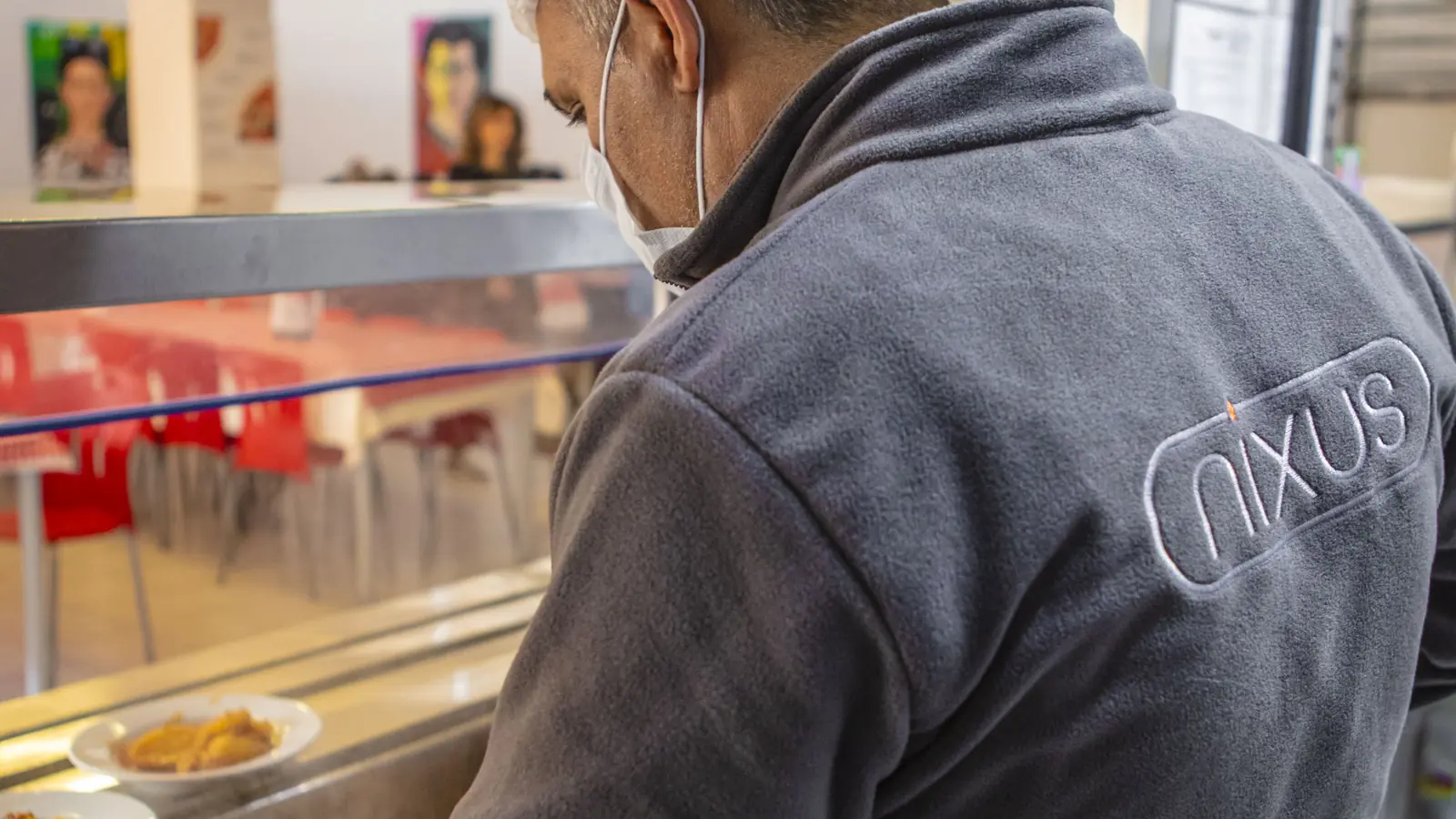 Nixus Catering üniformalı personel servis bandında yemek hazırlıyor